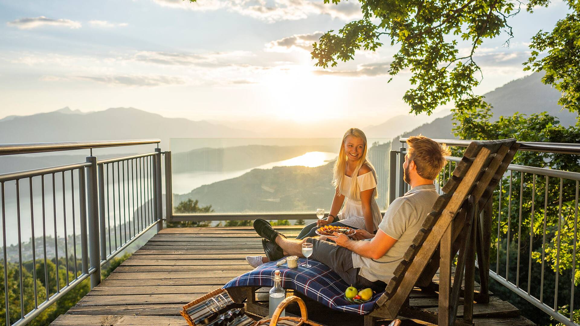 Pärchen genießt auf Bank mit einem Picknick am Sternenbalkon die Sonne