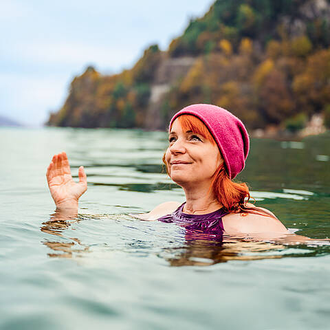 Frau ist mit Mütze im Herbst im Millstätter See Kaltbaden