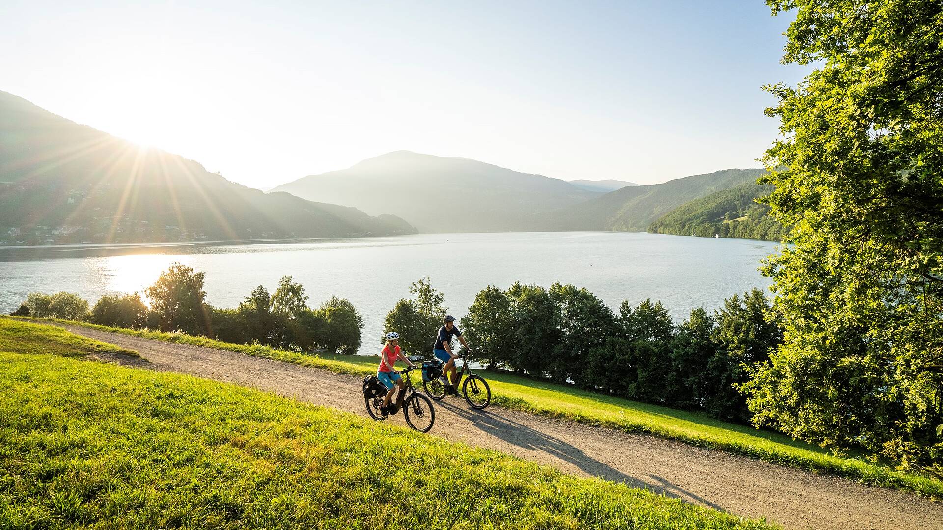 2 Personen fahren mit ihren Rädern den Radweg um den Millstätter See entlang